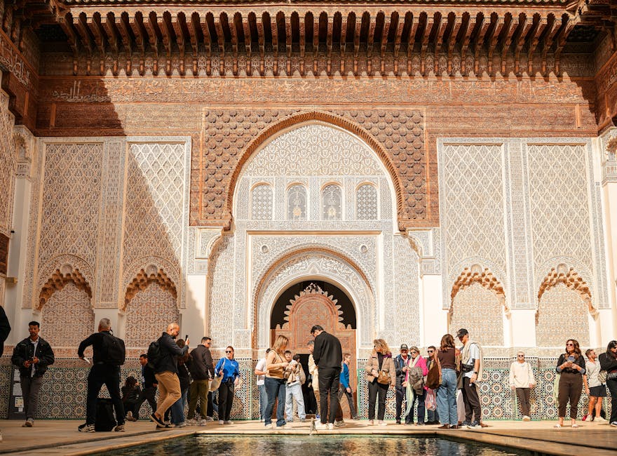 Group of students exploring Ben Youssef Madrasa's intricate architecture in sunny Marrakech.