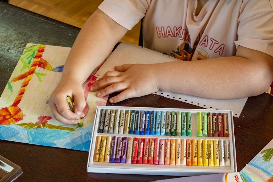 A child drawing vibrant artwork using oil pastels on paper, focusing on creativity and art.